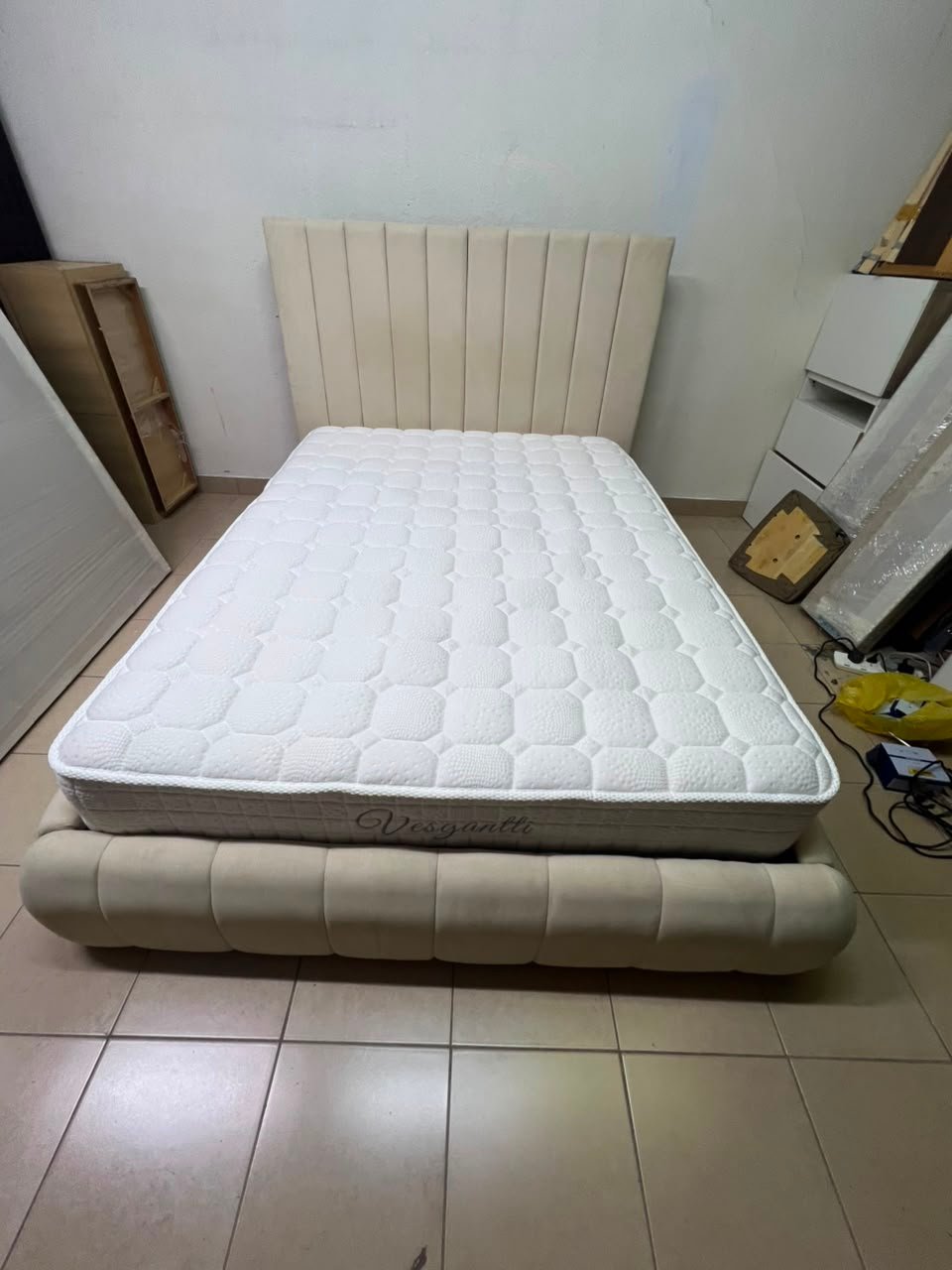 The cream-colored upholstered bed features a stylish and comfortable headboard. - Image 13