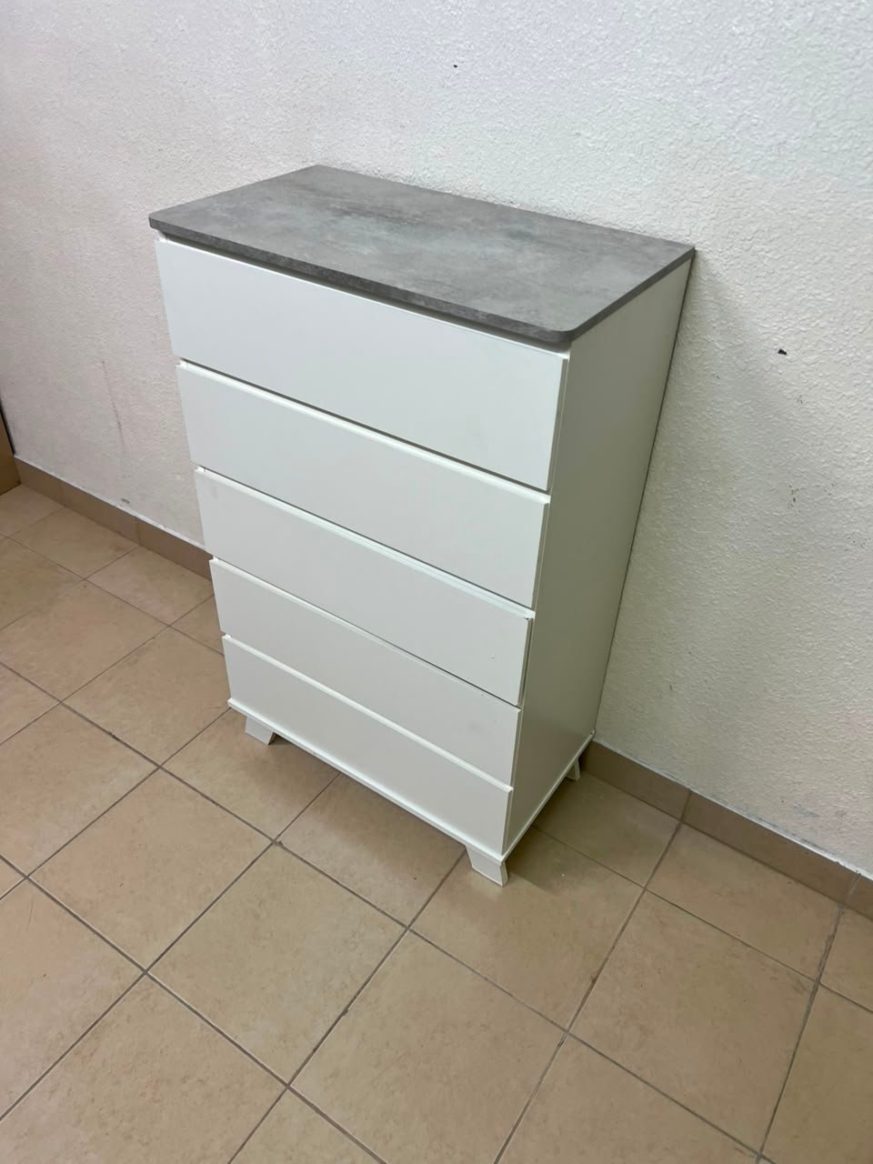 A modern white chest of drawers with a concrete-gray top, similar to models like the Colin from IKEA