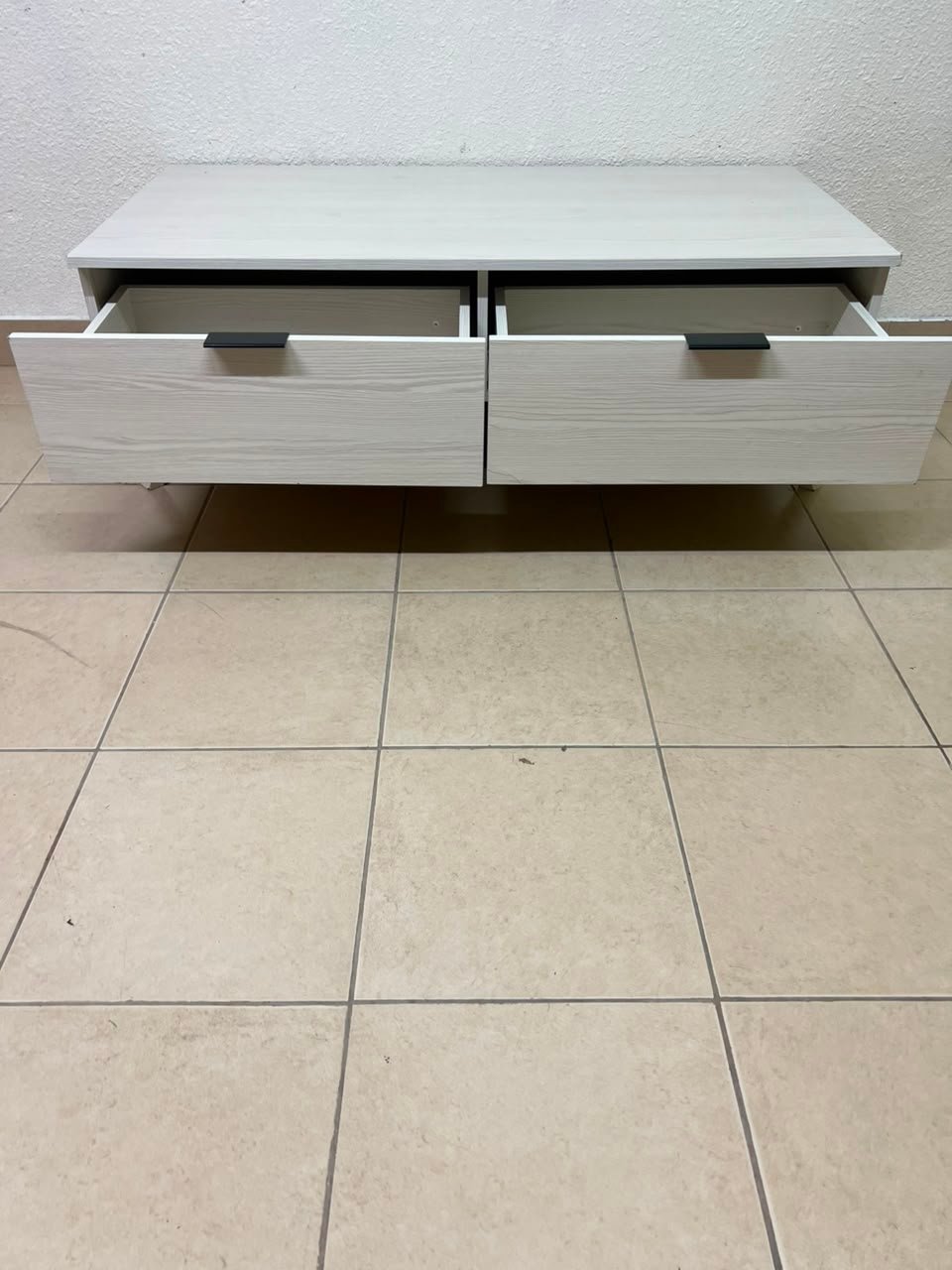 The white Wayne coffee table from Home Centre features two spacious drawers with black handles. - Image 9