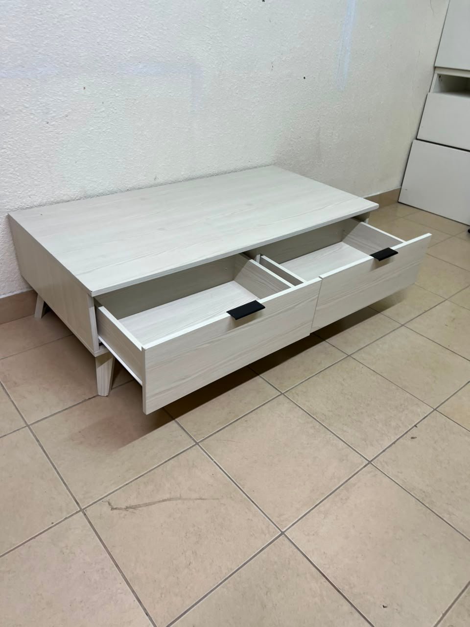 The white Wayne coffee table from Home Centre features two spacious drawers with black handles. - Image 14