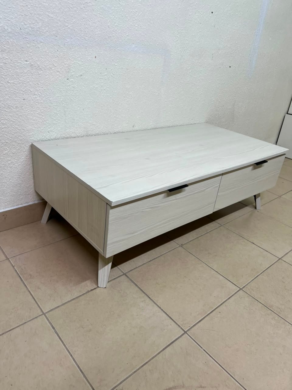 The white Wayne coffee table from Home Centre features two spacious drawers with black handles. - Image 10