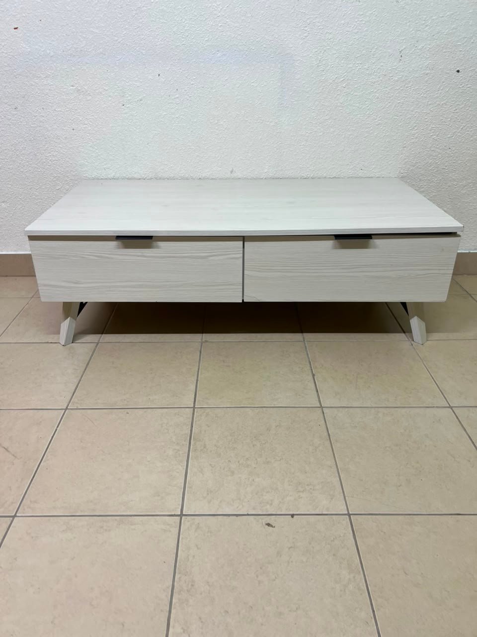 The white Wayne coffee table from Home Centre features two spacious drawers with black handles. - Image 7