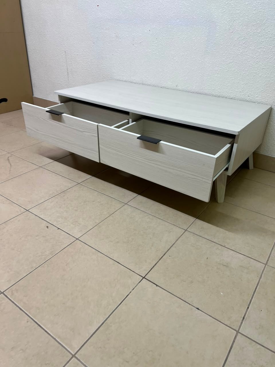 The white Wayne coffee table from Home Centre features two spacious drawers with black handles. - Image 5