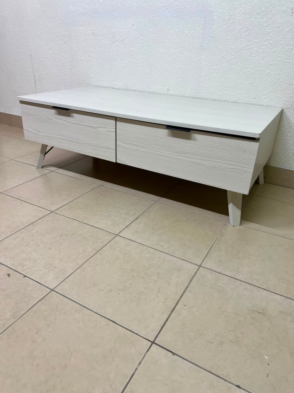 The white Wayne coffee table from Home Centre features two spacious drawers with black handles.
