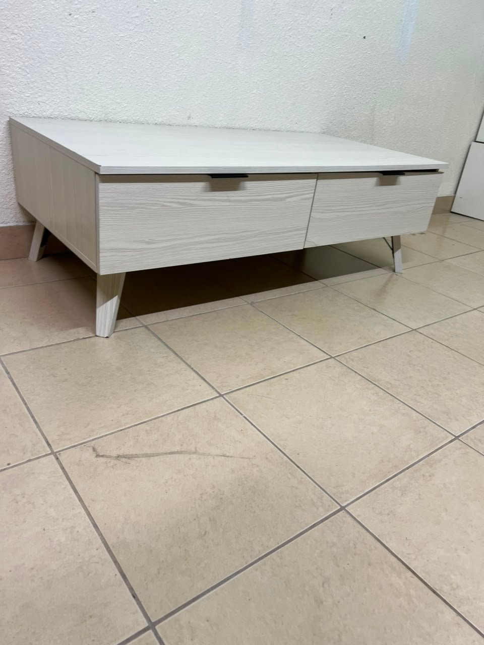 The white Wayne coffee table from Home Centre features two spacious drawers with black handles. - Image 13