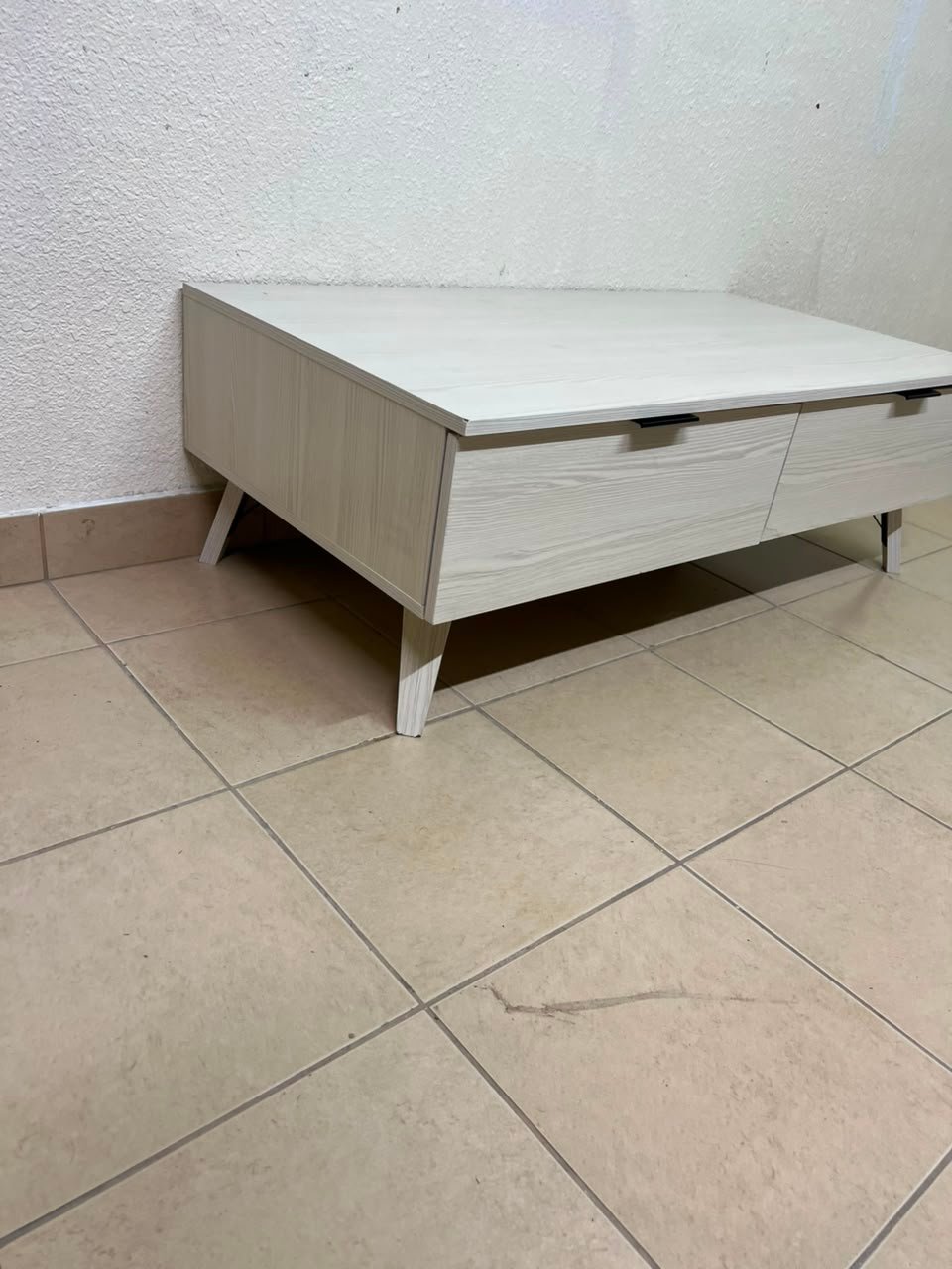 The white Wayne coffee table from Home Centre features two spacious drawers with black handles. - Image 2