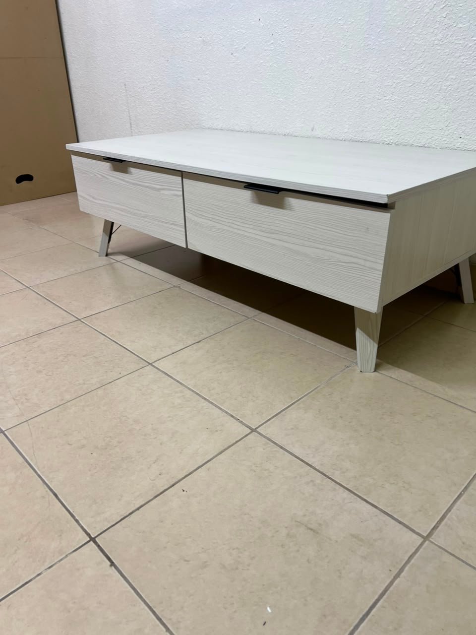 The white Wayne coffee table from Home Centre features two spacious drawers with black handles. - Image 11