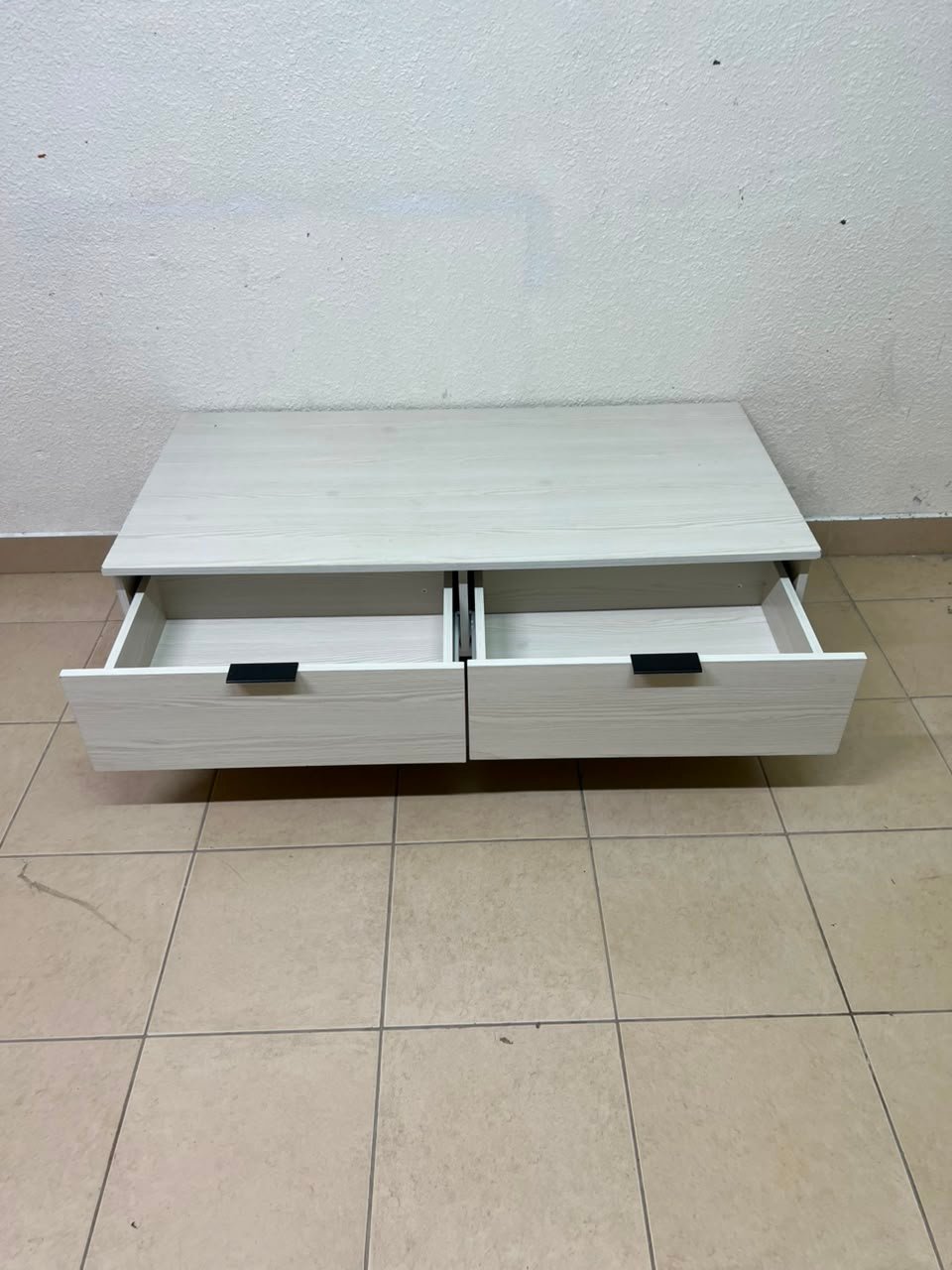 The white Wayne coffee table from Home Centre features two spacious drawers with black handles. - Image 4
