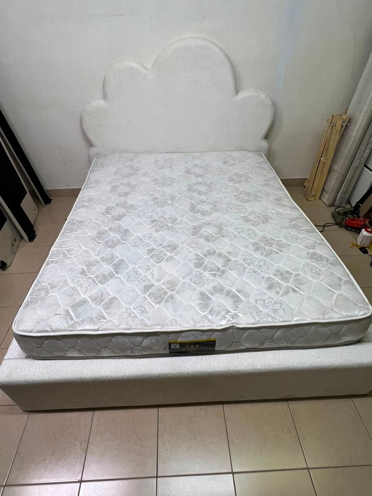 A fully upholstered white frame bed featuring a unique cloud-shaped headboard design. - Image 4