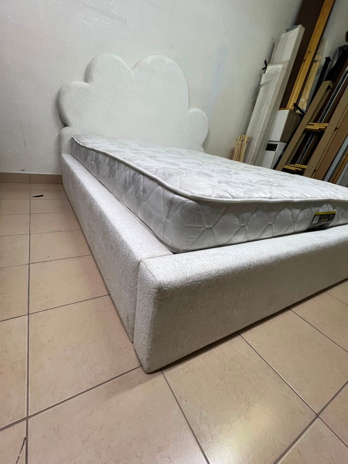 A fully upholstered white frame bed featuring a unique cloud-shaped headboard design. - Image 6