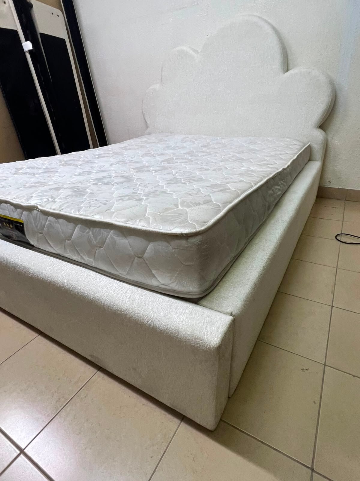 A fully upholstered white frame bed featuring a unique cloud-shaped headboard design. - Image 10