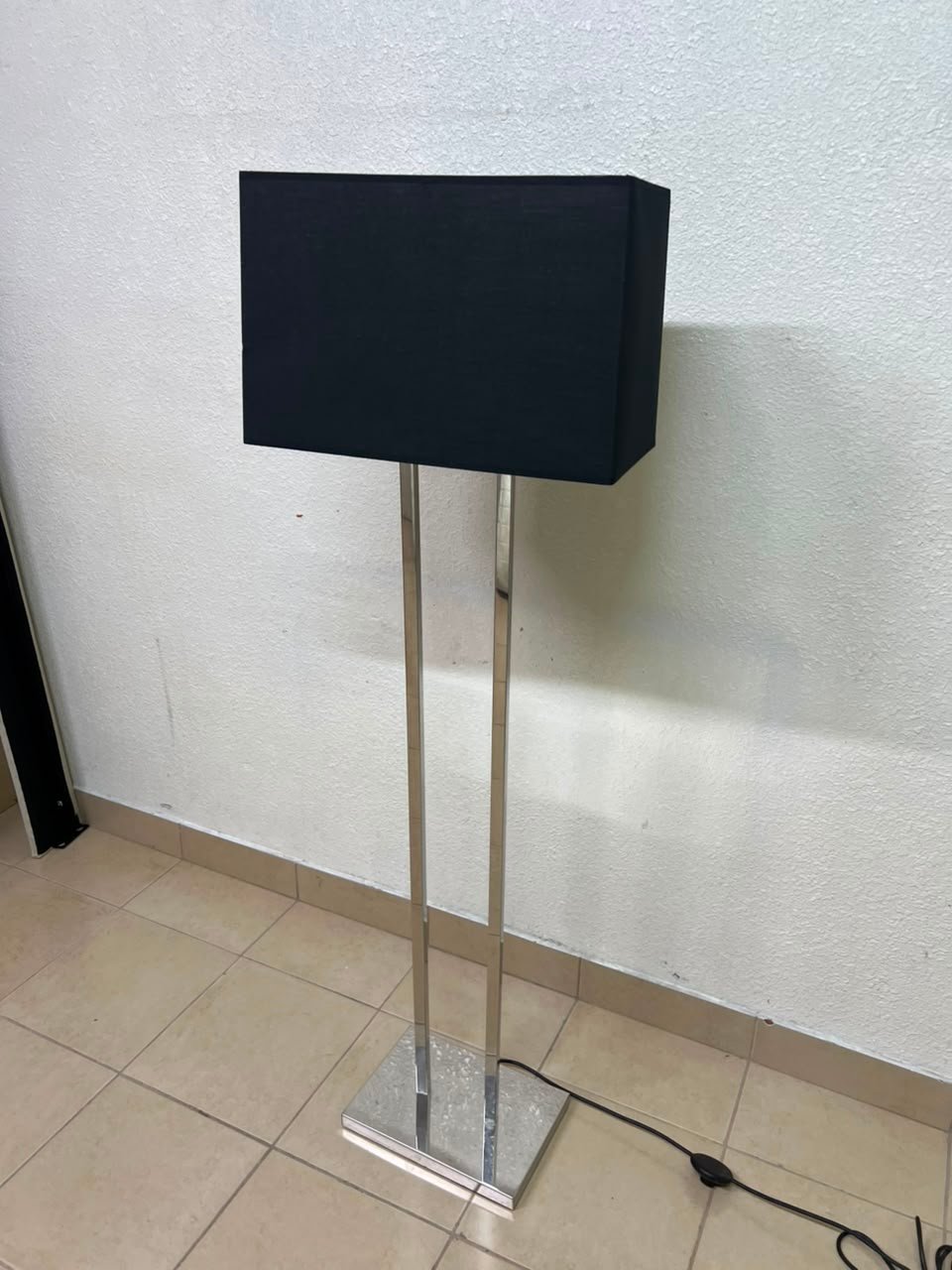 This modern floor lamp features a chrome-plated metal frame and a black fabric cover. - Image 10