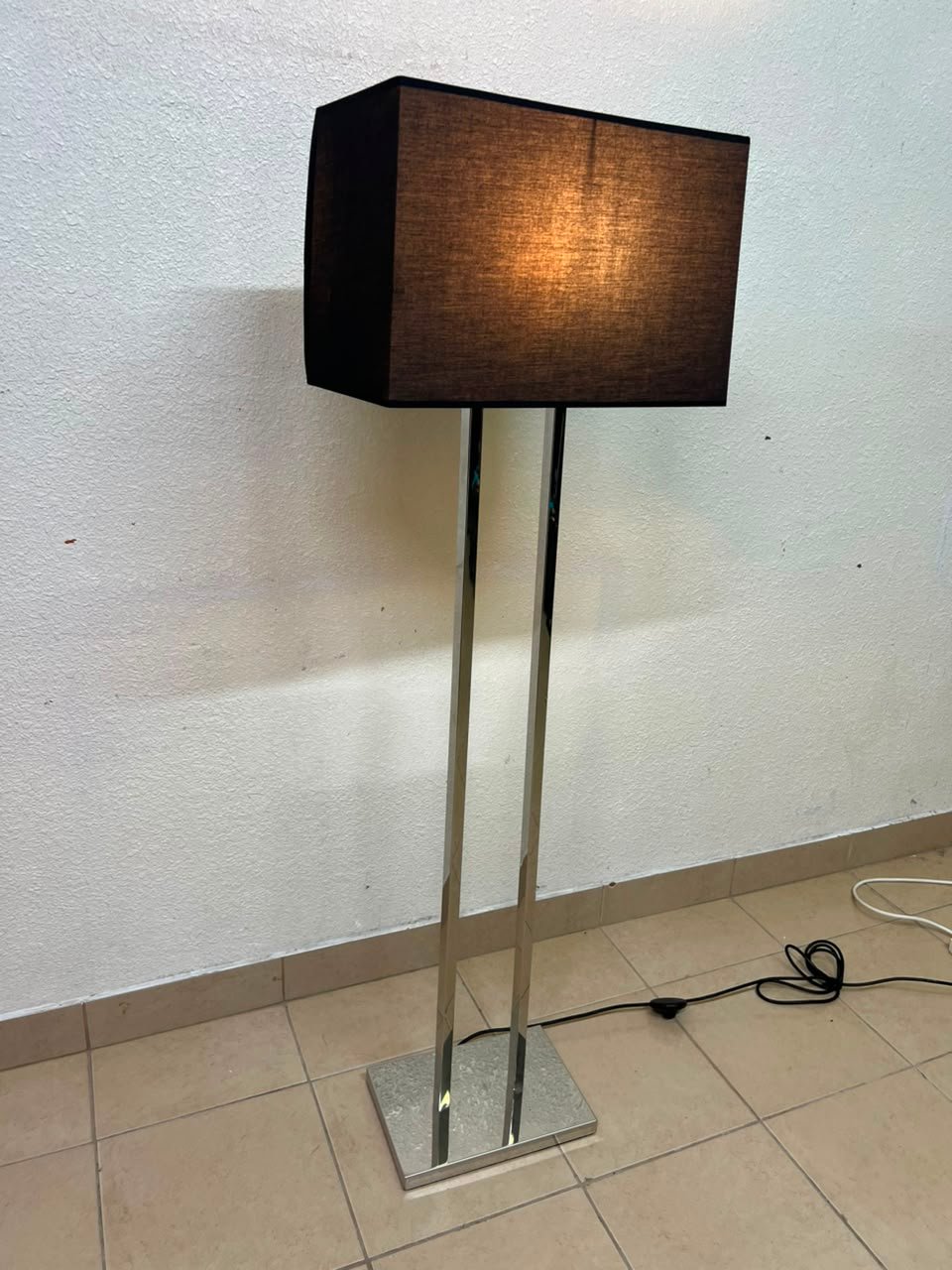 This modern floor lamp features a chrome-plated metal frame and a black fabric cover. - Image 2