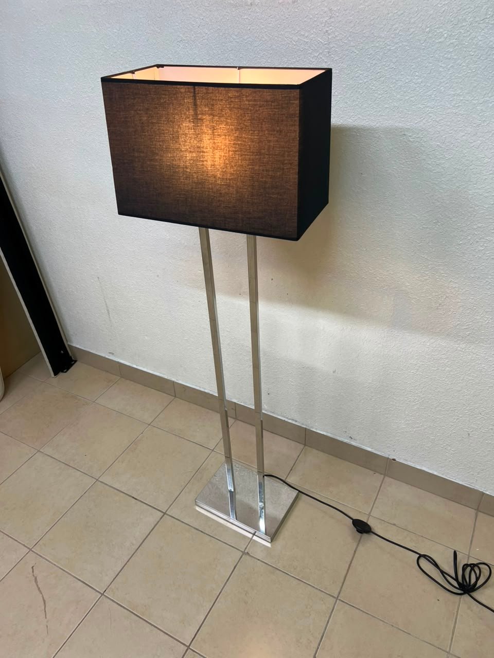 This modern floor lamp features a chrome-plated metal frame and a black fabric cover. - Image 5