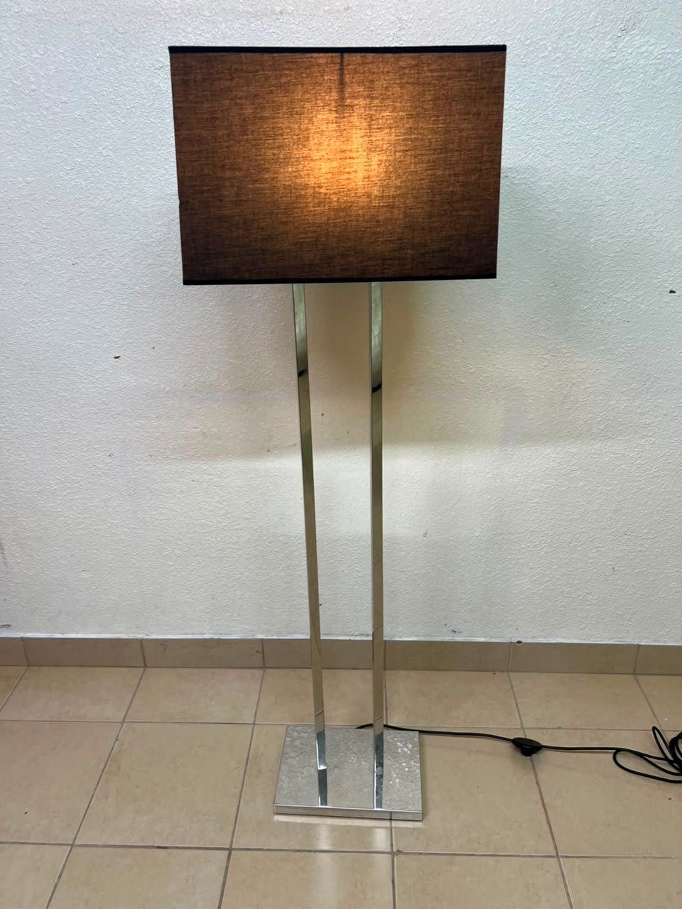This modern floor lamp features a chrome-plated metal frame and a black fabric cover. - Image 4