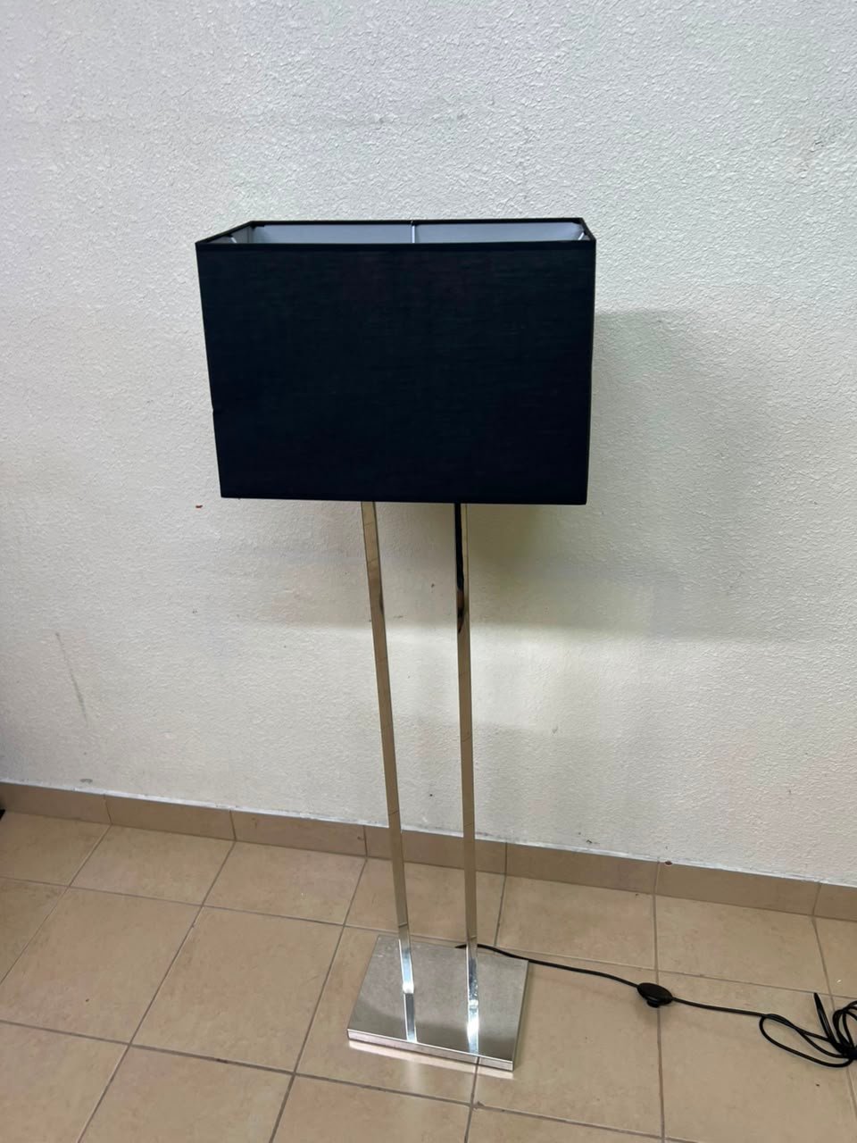 This modern floor lamp features a chrome-plated metal frame and a black fabric cover. - Image 8