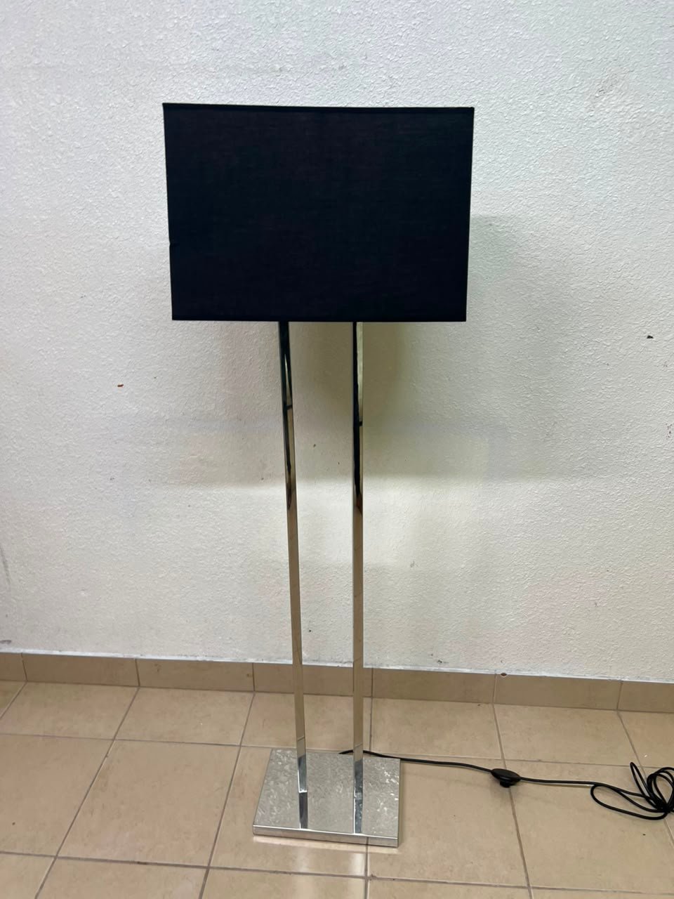This modern floor lamp features a chrome-plated metal frame and a black fabric cover. - Image 9