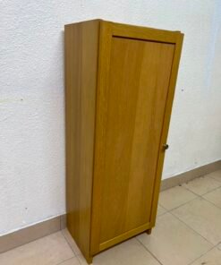 A narrow storage cabinet, either IKEA-style or similar, featuring a natural oak veneer finish.