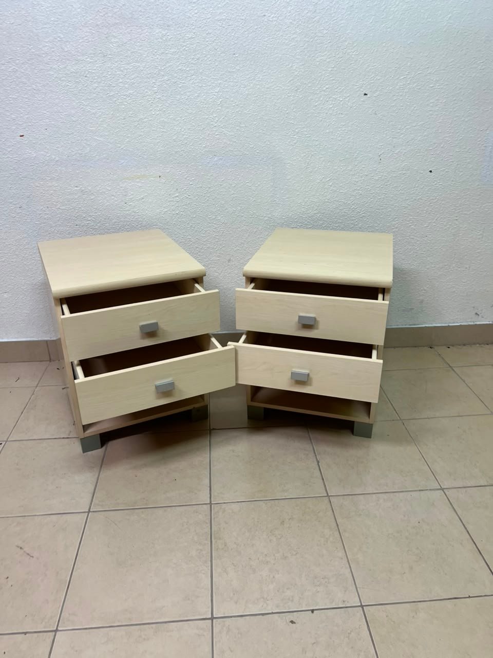 A set of two modern bedside tables in a light wood color with two drawers and open storage space. - Image 15
