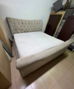 A classic diamond-patterned quilted bed with a mattress featuring soft velvet fabric in beige or gray.