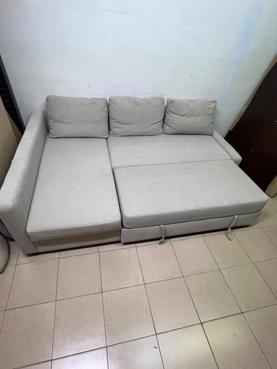 The IKEA FRIHETEN corner sofa that converts into a bed features a light gray color and a practical design that includes storage space. - Image 11