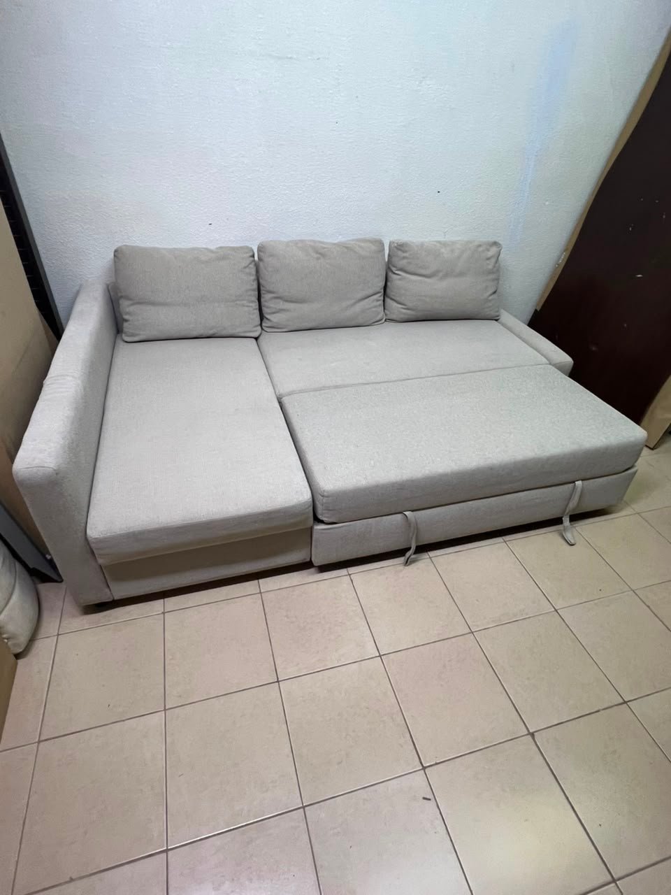 The IKEA FRIHETEN corner sofa that converts into a bed features a light gray color and a practical design that includes storage space. - Image 12