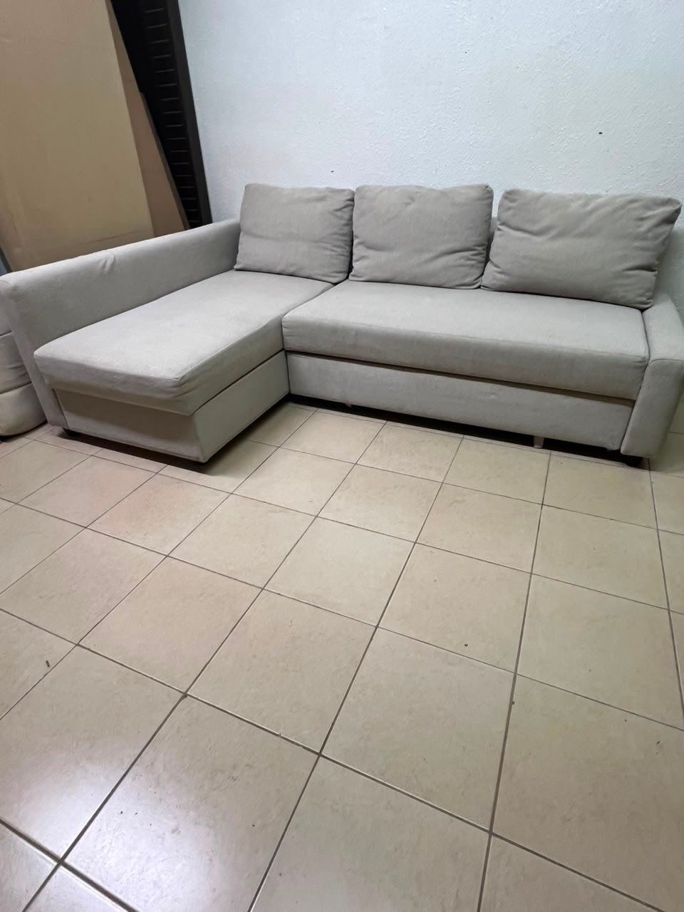 The IKEA FRIHETEN corner sofa that converts into a bed features a light gray color and a practical design that includes storage space. - Image 3
