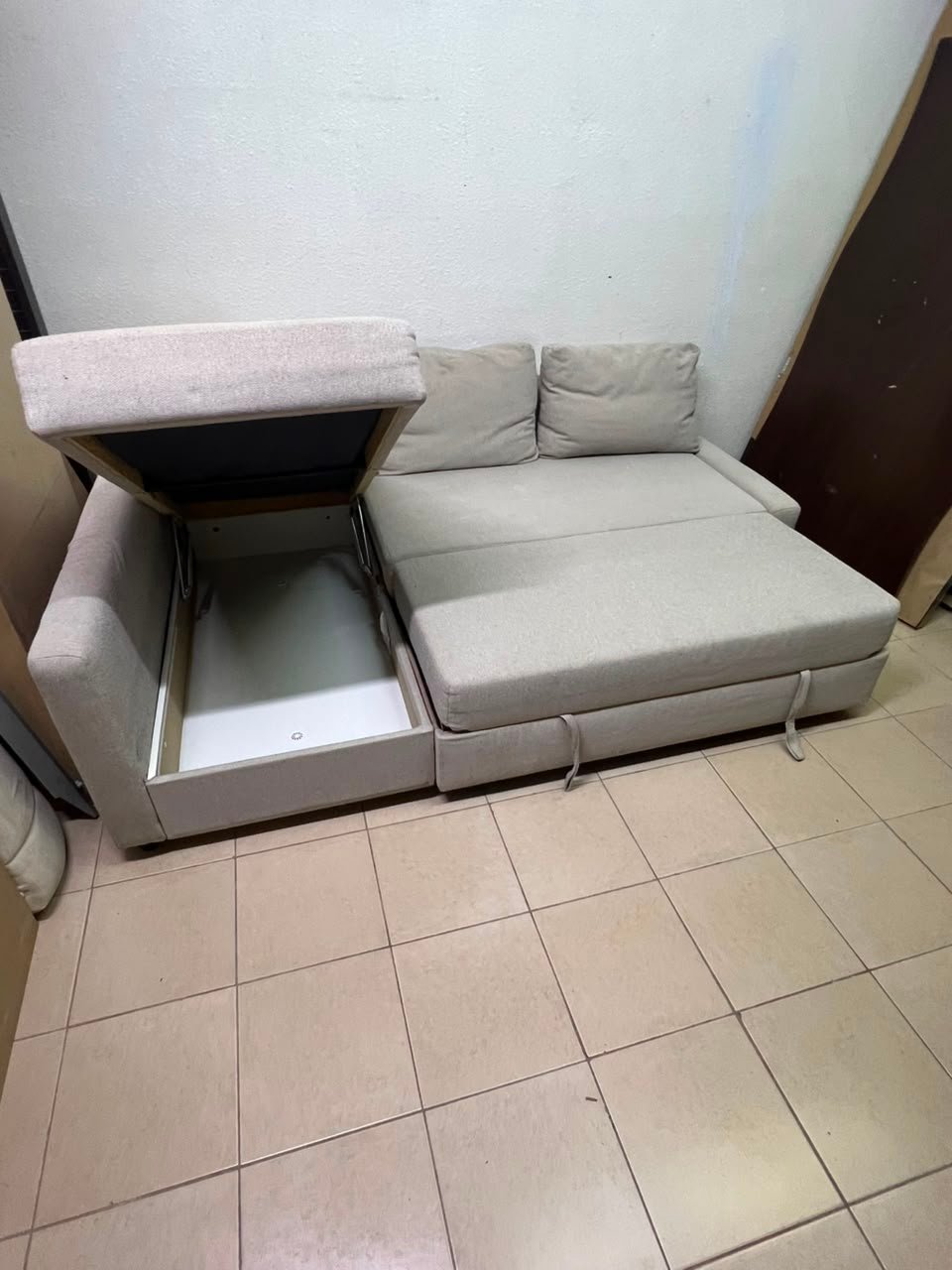 The IKEA FRIHETEN corner sofa that converts into a bed features a light gray color and a practical design that includes storage space. - Image 4