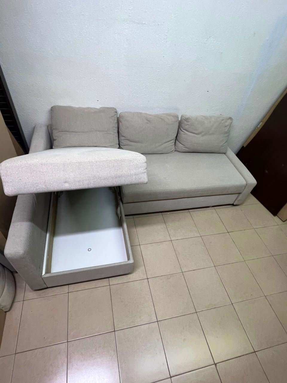 The IKEA FRIHETEN corner sofa that converts into a bed features a light gray color and a practical design that includes storage space. - Image 6