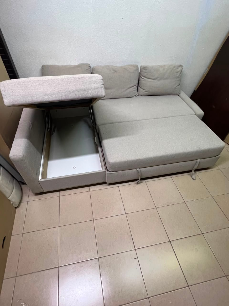 The IKEA FRIHETEN corner sofa that converts into a bed features a light gray color and a practical design that includes storage space. - Image 7