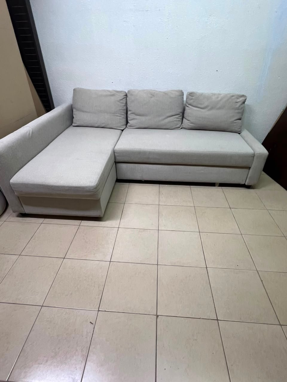 The IKEA FRIHETEN corner sofa that converts into a bed features a light gray color and a practical design that includes storage space. - Image 9