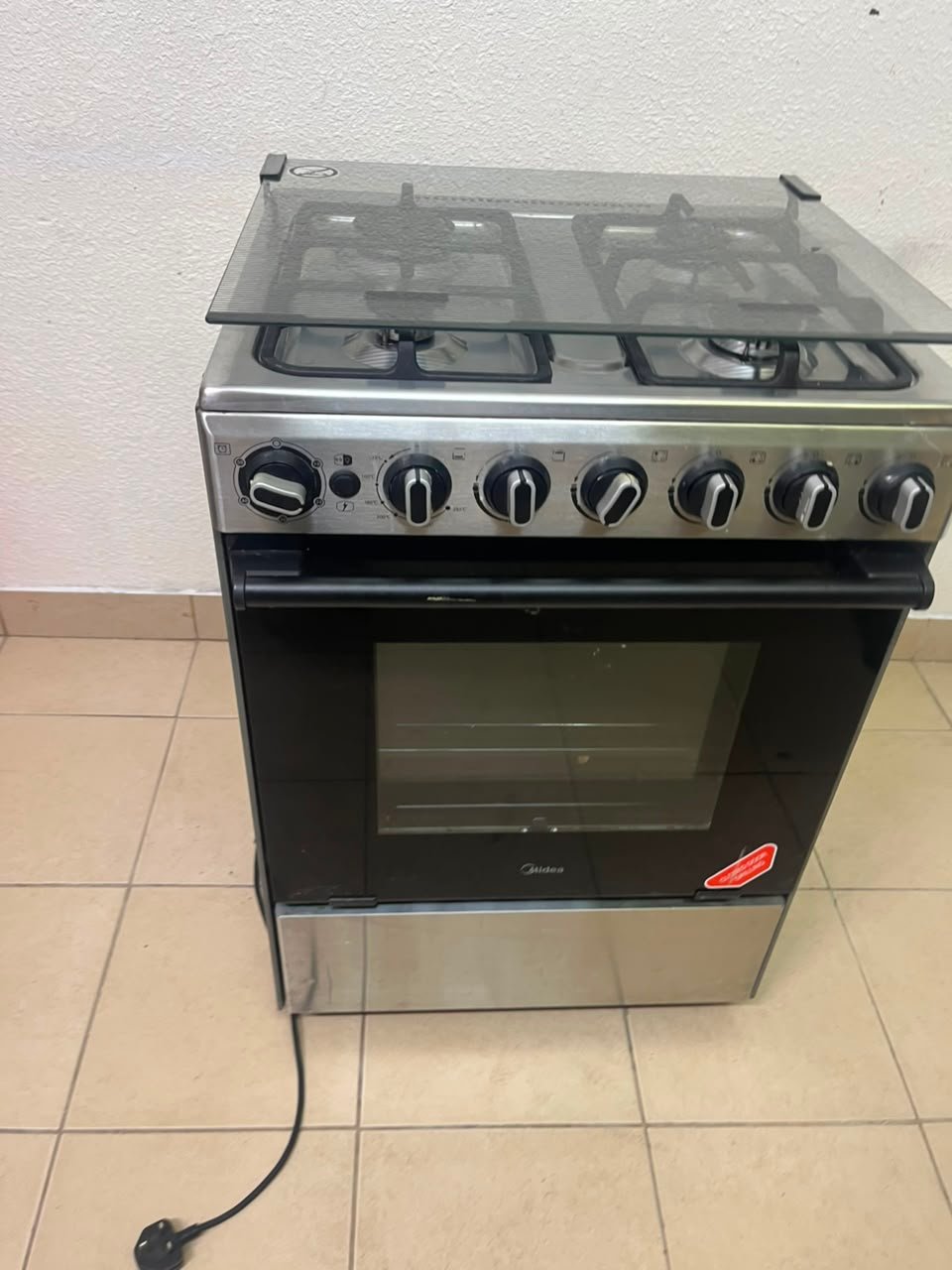 Midea Freestanding 4-Burner Gas Cooker with Oven – Stainless Steel Stove with Foldable Glass Lid & Storage Drawer