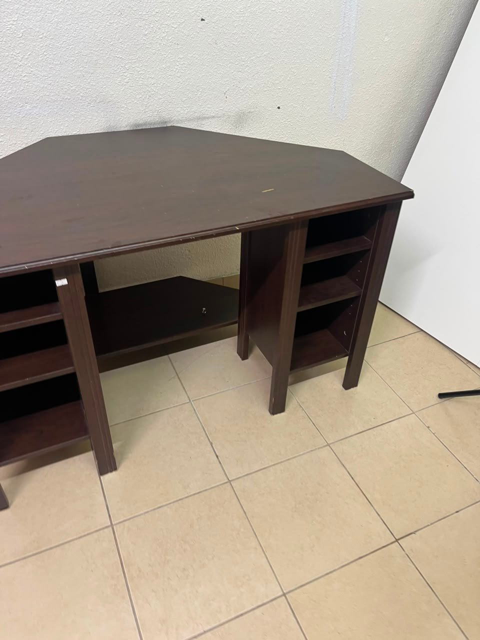 IKEA BRUSALI corner desk in brown featuring built-in storage shelves on the sides.