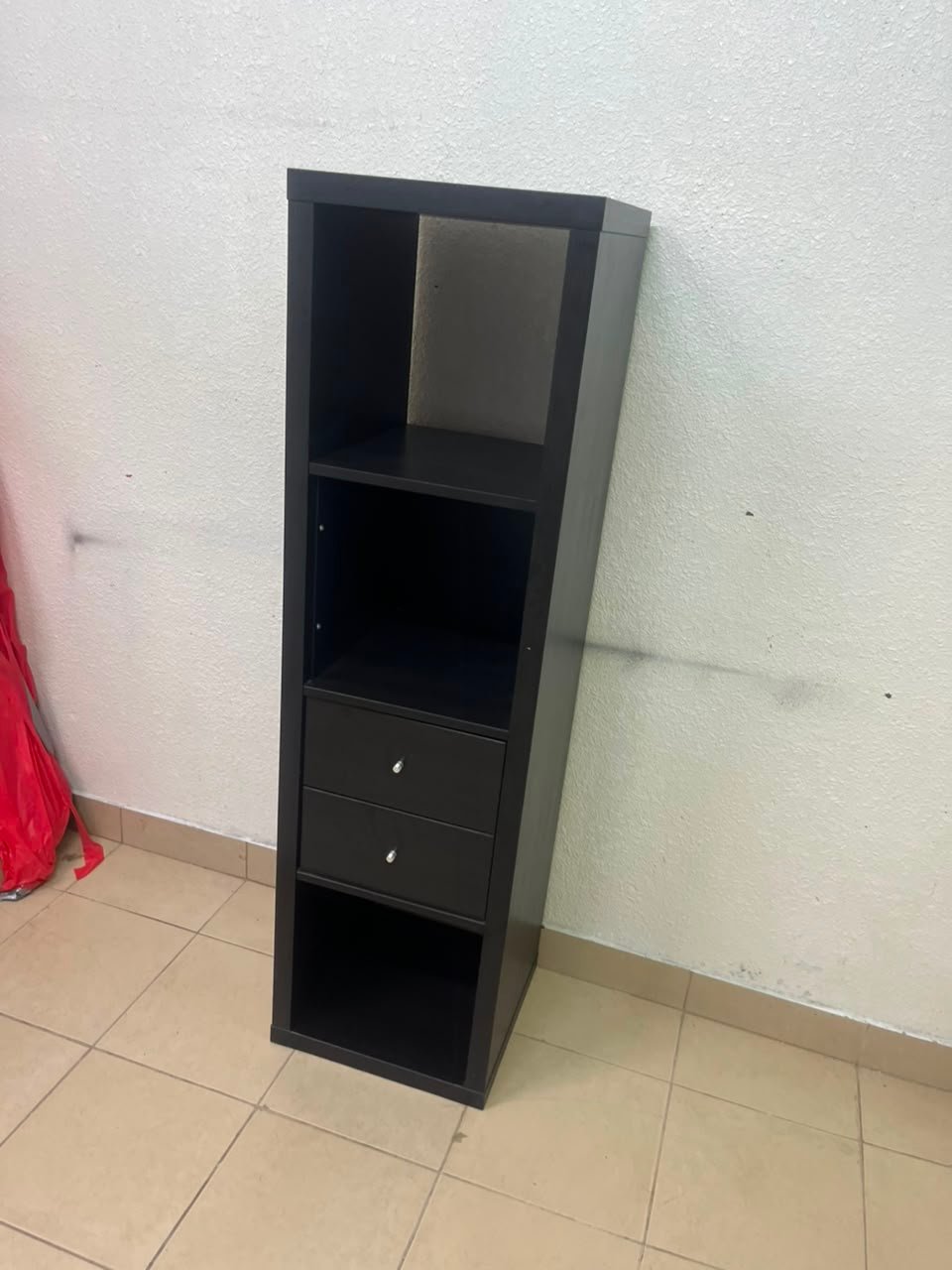 The IKEA KALLAX shelving unit, in black and brown, features a vertical design with built-in drawer units.