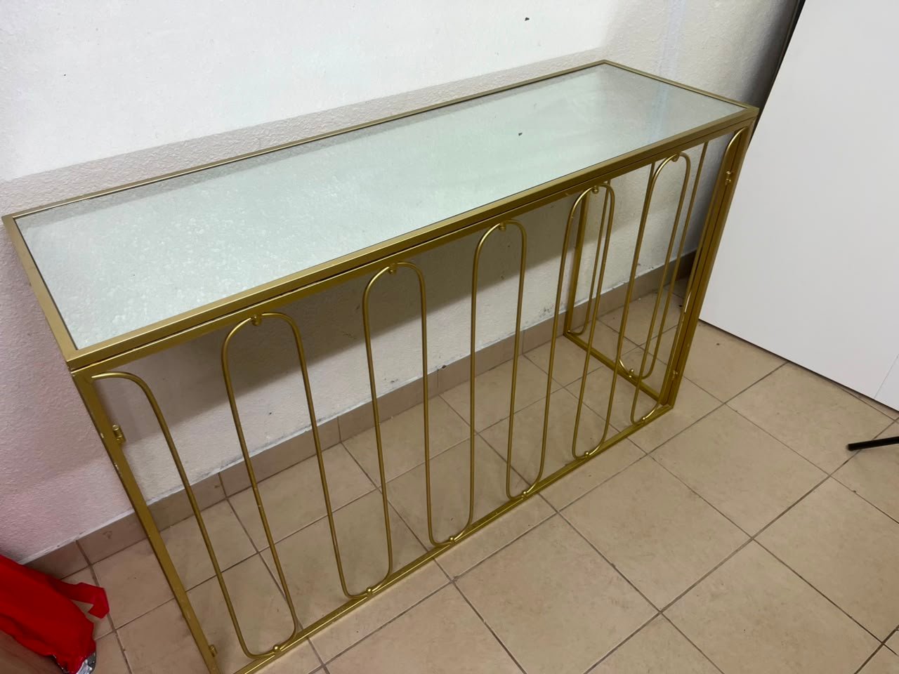 Modern console table with a gold metal frame and reflective glass top - Image 2