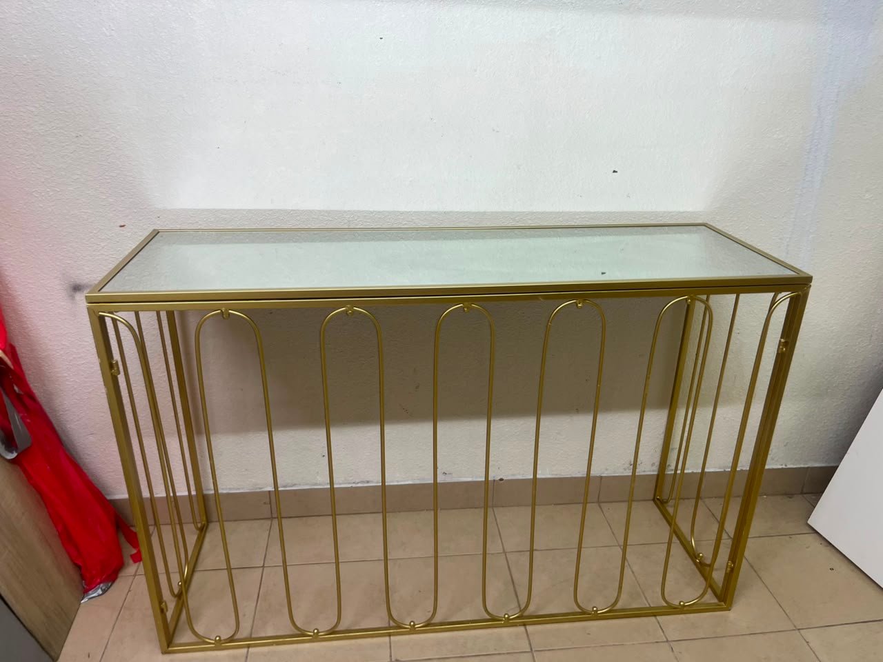 Modern console table with a gold metal frame and reflective glass top - Image 4