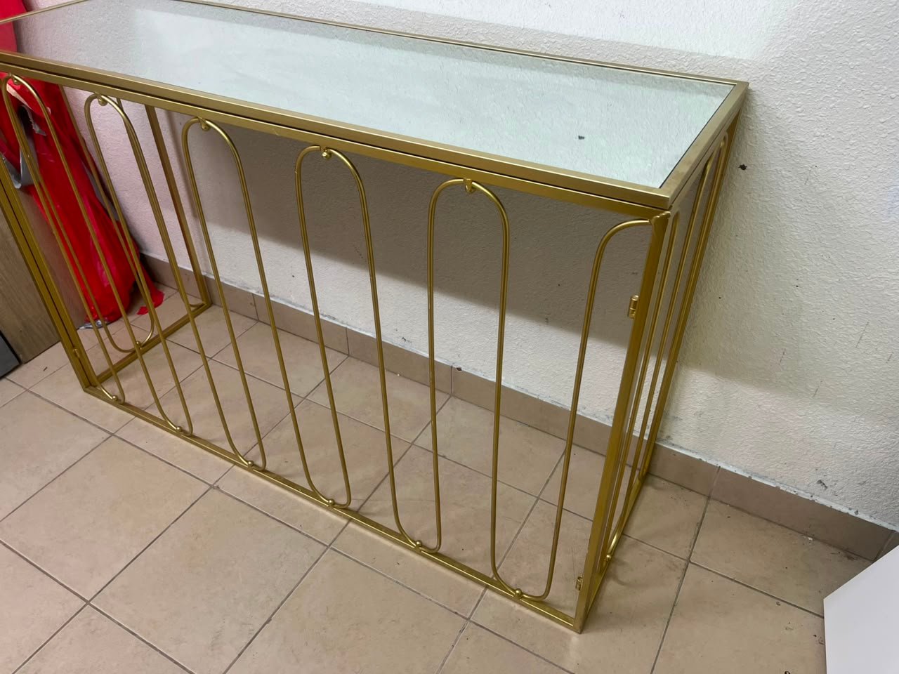 Modern console table with a gold metal frame and reflective glass top - Image 5