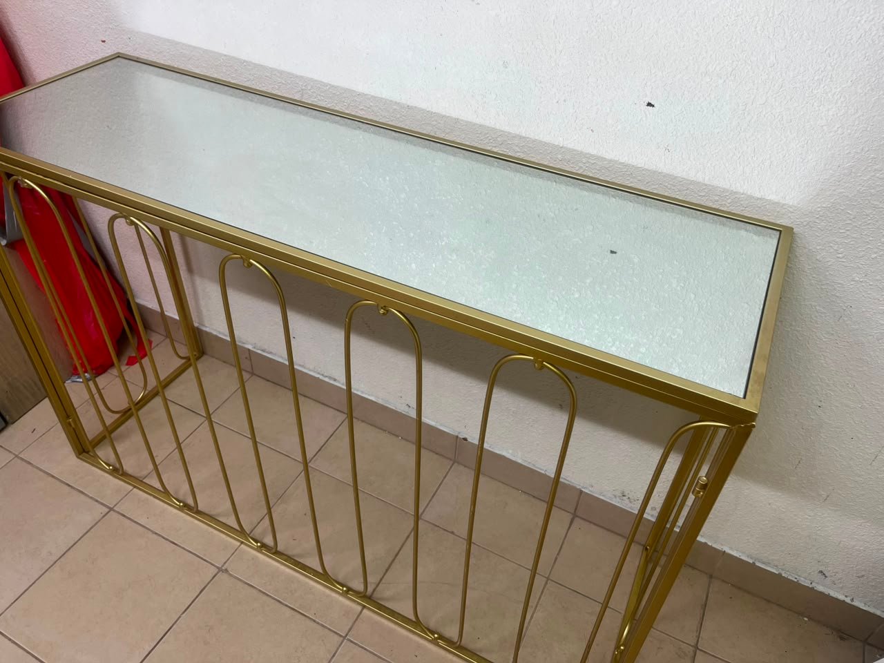 Modern console table with a gold metal frame and reflective glass top - Image 6