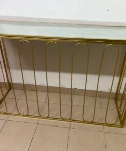 Modern console table with a gold metal frame and reflective glass top