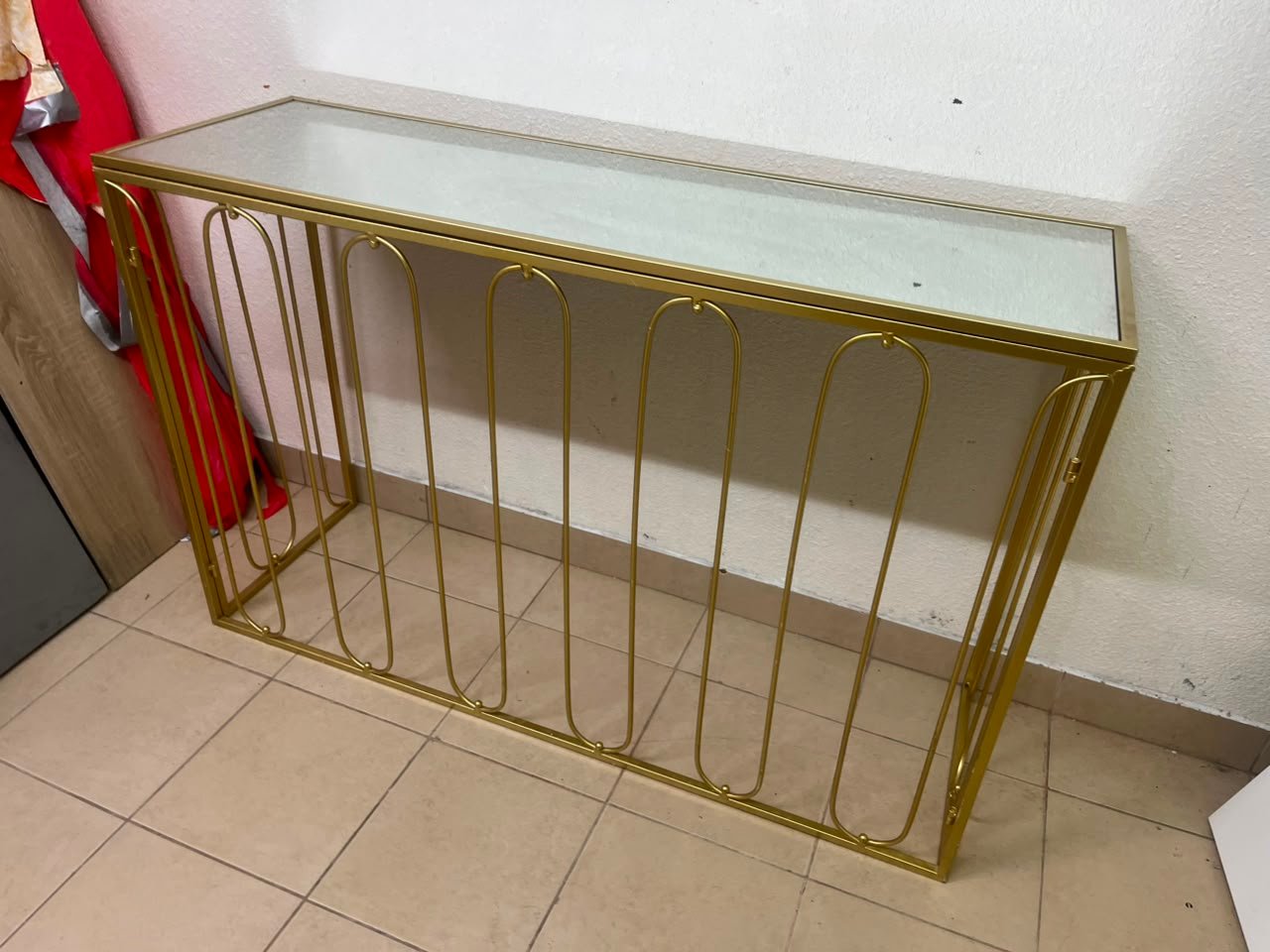 Modern console table with a gold metal frame and reflective glass top - Image 11