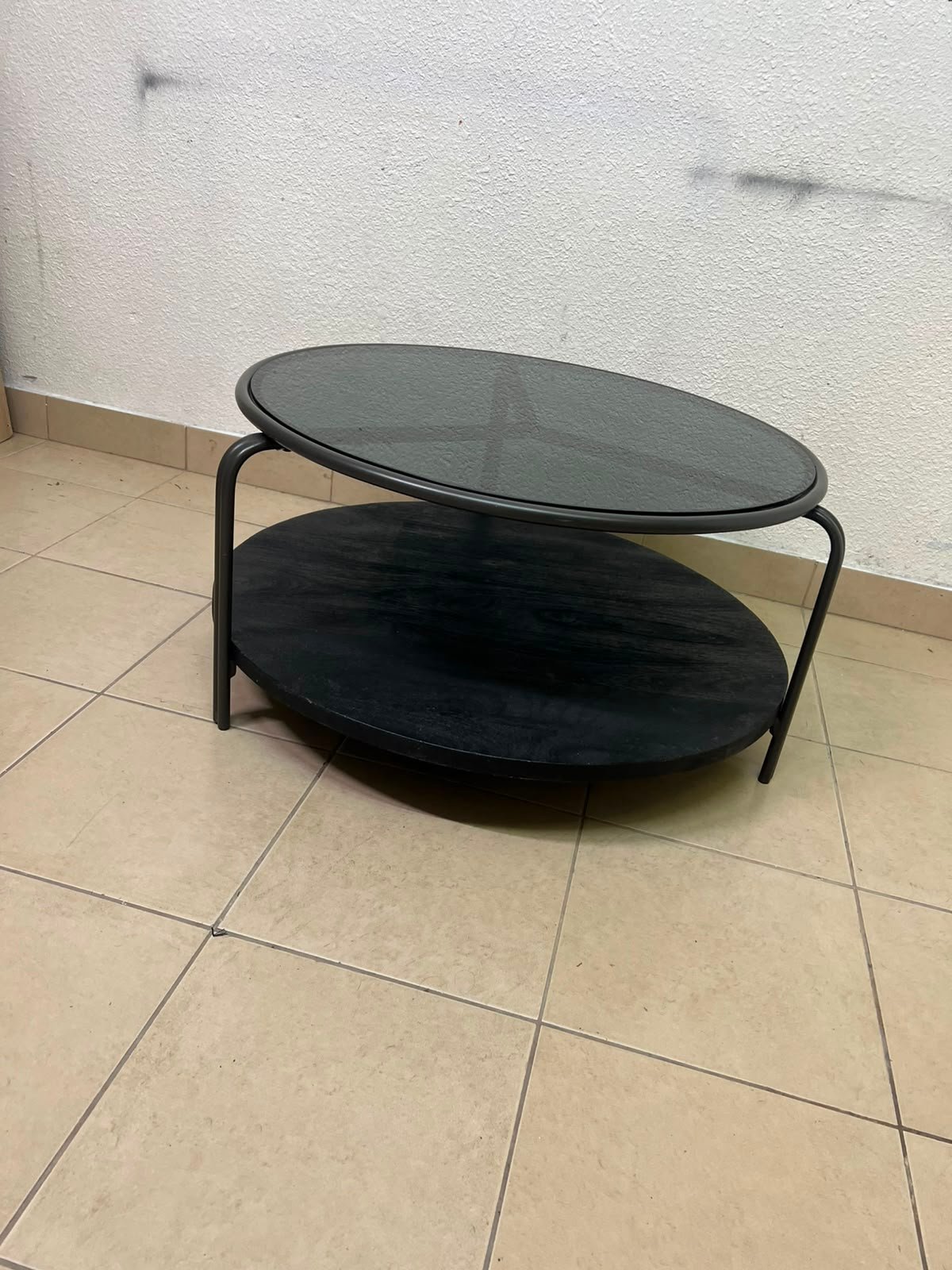 Where Saints Go's "Zenith" round coffee table with a dark glass top and black metal frame - Image 2