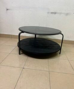 Where Saints Go's "Zenith" round coffee table with a dark glass top and black metal frame - Image 7
