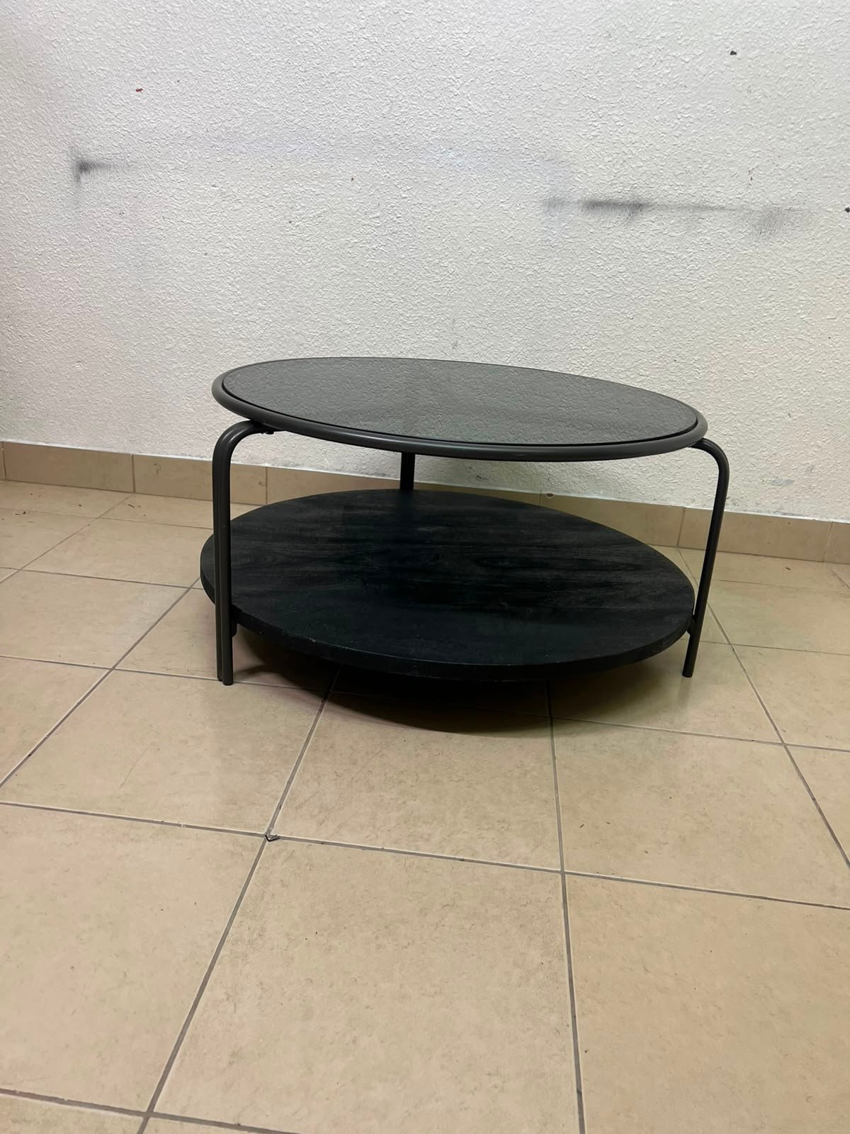 Where Saints Go's "Zenith" round coffee table with a dark glass top and black metal frame - Image 7