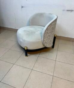 The chair is a Grayson model from Casarina Interiors, featuring a curved velvet seat and gold metal legs.