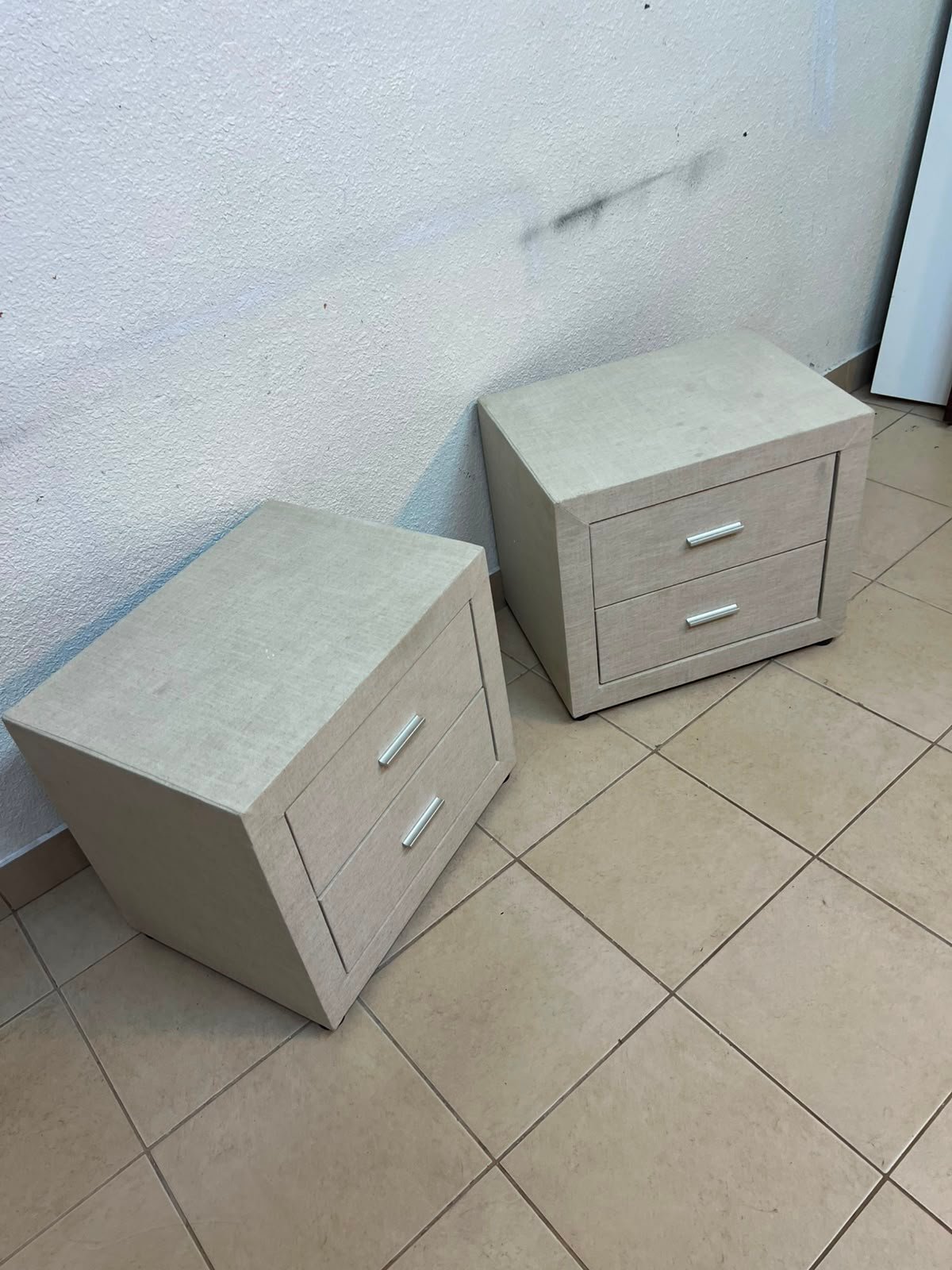 A beige upholstered nightstand with two drawers and silver handles. - Image 4
