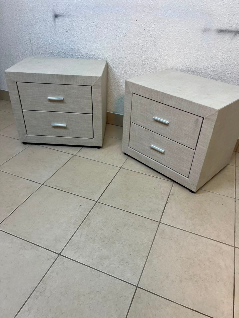 A beige upholstered nightstand with two drawers and silver handles. - Image 5