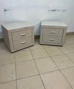A beige upholstered nightstand with two drawers and silver handles. - Image 2