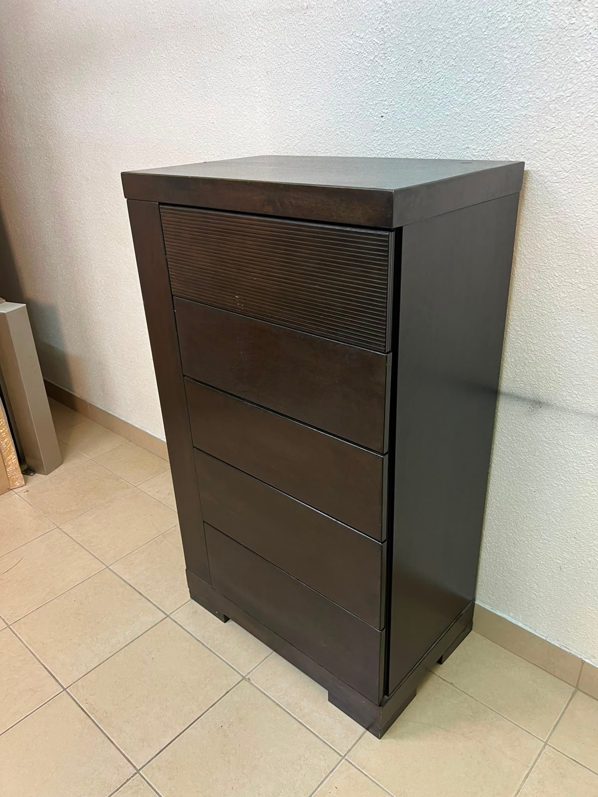 A Home Centre Geneva-style chest of drawers, featuring a dark brown color and solid wood design with 5 drawers.