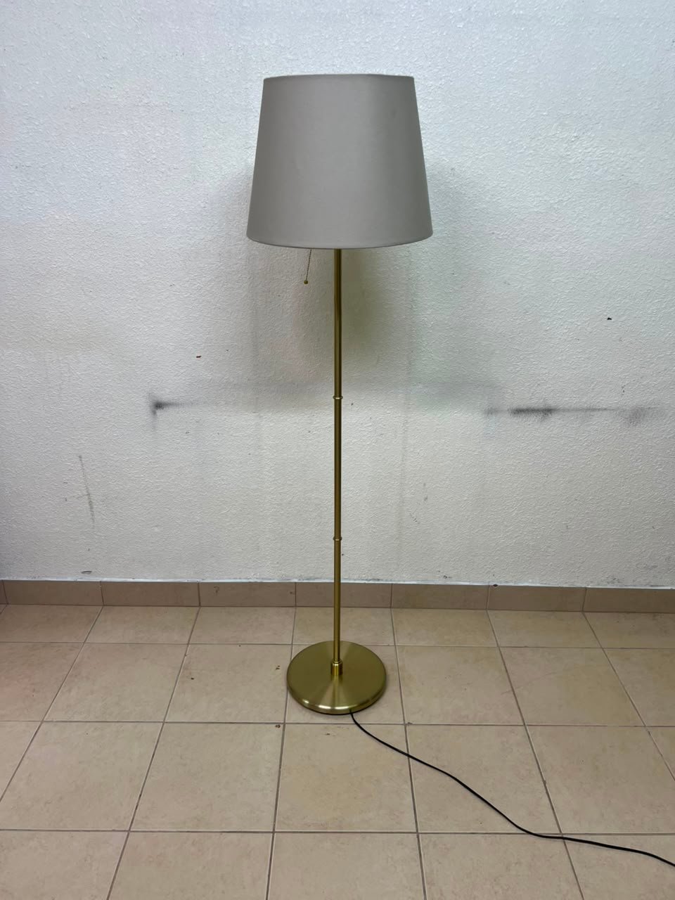 A modern and elegant floor lamp (lampade) with a slim, copper-gold metal base and a warm fabric shade. - Image 5