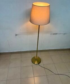 A modern and elegant floor lamp (lampade) with a slim, copper-gold metal base and a warm fabric shade. - Image 3